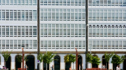 Gente paseando por la Marina, en A Coruña, con las galerías al fondo