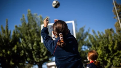 25-10-2021 Una niña juega al baloncesto en el patio del Colegio Alameda de Osuna el día en que entra en vigor la medida que permite no utilizar mascarilla en los patios escolares de Madrid, a 25 de octubre de 2021, en Madrid, (España). Con este permiso, que entra en vigor este lunes, Madrid se convierte en la primera comunidad autónoma que permite no llevar mascarilla en los patios de los colegios de la región, en los recreos y al aire libre, siempre y cuando se respete la distancia de seguridad interpersonal establecida por la pandemia. Esta medida, puesta en marcha por la Comunidad de Madrid, ha sido criticada por Sanidad, quien ha recordado que no se puede decidir unilateralmente la retirada de la mascarilla en los patios escolares ya que la ley en vigor desde el 29 de marzo establece el uso obligatorio en espacios al aire libre donde no sea posible mantener una distancia mínima de 1,5 metros.SOCIEDAD Alejandro Martínez Vélez - Europa Press