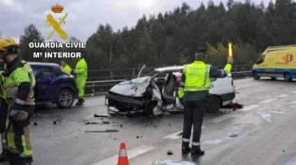 Un agente de la Guardia civil ante el vehículo siniestrado