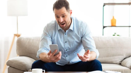 Hombre enojado gritando al teléfono móvil en casa