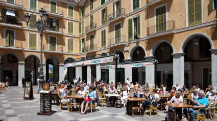 Personas sentadas en mesas en la Plaza Mayor de Palma de Mallorca