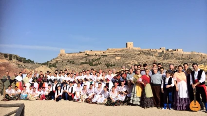 El grupo Coros y Danzas de Lorca posa ante el castillo de la ciudad con trajes tradicionales
