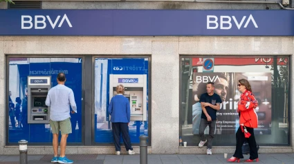 Un cliente retira dinero mientras otros hacen cola en un cajero automático del banco multinacional español Banco Bilbao Vizcaya Argentaria SA (BBVA) en España