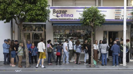 Gente en la cola de un bazar