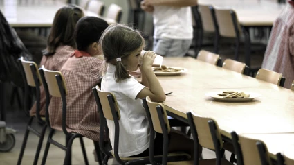 Una niña, en el comedor escolar
