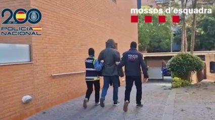 Agentes de Mossos y Policía Nacional retienen a uno de los detenidos