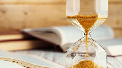 2H0H4KW Hourglass with sand close up on wooden background