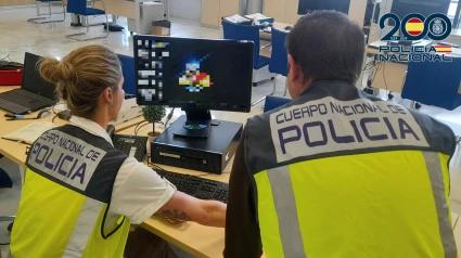 Agentes de la Policía Nacional delante de un ordenador