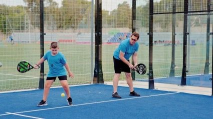 Un niño y un hombre juegan a pádel en el polideportivo de Sant Ferran
