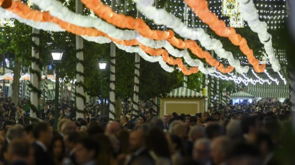 La Feria de Abril de Sevilla, la de la vuelta a la fiesta de una semana de duración ya está en marcha oficialmente, tras encenderse el alumbrado, como siempre, a las 12.00 de la noche en punto, al mismo tiempo en su impresionante portada que en las 15 calles de su Real