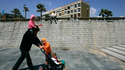 Hombre empujando un cochecito con sus hijos en Barcelona