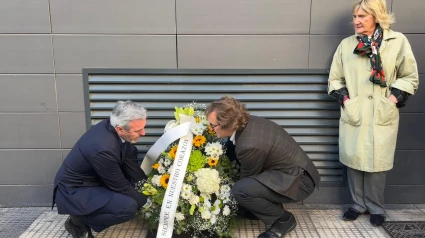 Manuel Giménez Larraz, hijo de la víctima; y el presidente Azcón, depositan flores en el lugar del atentado, bajo la atenta mirada de su viuda, Ana