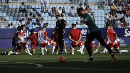 Jugadores del Granada calientan en el último partido disputado en La Rosaleda
