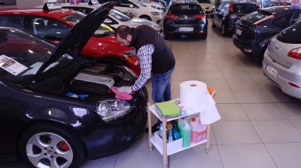 Un trabajador de un concesionario comprueba el motor de un vehículo