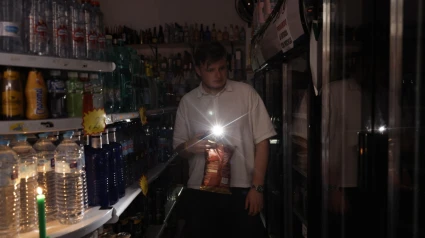 Una persona utiliza su teléfono móvil como linterna en un ultramarinos