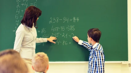 Una profesora de matemáticas enseñando a un alumno