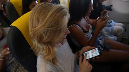 Una bloquera de moda usa el dispositivo móvil durante un vuelo de Vueling hacia Split (Croacia)