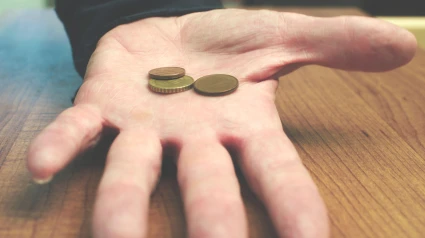 Céntimos de euro en la palma de la mano de un hombre