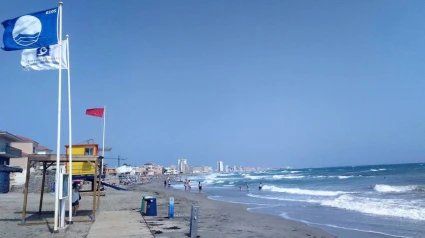 Una playa con bandera roja, que prohíbe el baño y entrar en el agua