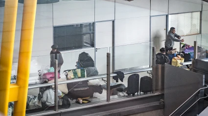 Varias personas se preparan para pernoctar en la T4 del Aeropuerto Adolfo Suárez-Madrid Barajas