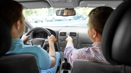 Un profesor de autoescuela da indicaciones a un alumno al volante