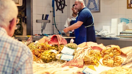 Pescadero en el mercado de Triana preparando pescado para un jubilado