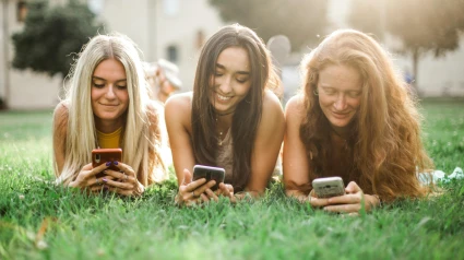 Chicas juegan con sus móviles
