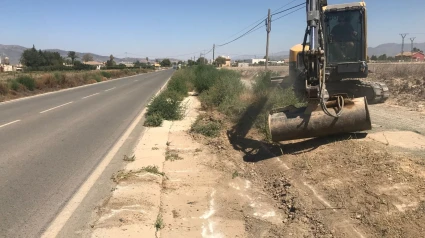 Un tractor desbroza la cuneta de una carretera en Lorca