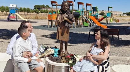 Familia de Eva junto a su estatua, en el parque en su honor en Daimiel