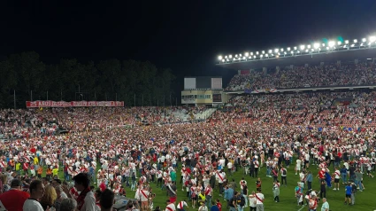 Los aficionados del Rayo celebran sobre el césped la clasificación europea del equipo.