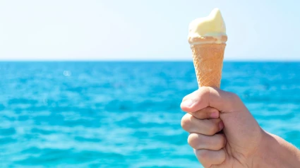 Una persona sujeta un helado en una playa