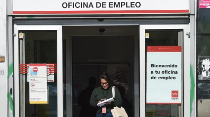 Una mujer sale de una oficina de empleo