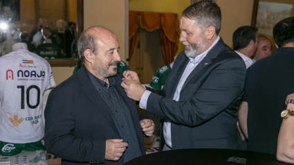 Juan Fernánez le coloca una insignia a Sebastián Moya de AM System