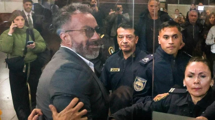 El doctor Leopoldo Luque, a la entrada de la audiencia, escoltado por agentes de policía