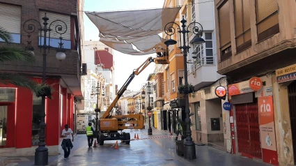 Montaje de los grandes toldos que cubrirán la calle Corredera de Lorca para dar sombra durante el verano