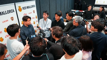 Asano rodeado de periodistas tras la renovación del patrocino en Japón