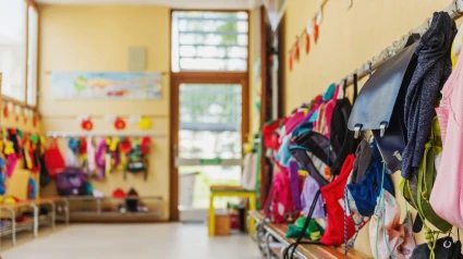 Mochilas de niños colgadas en un aula de guardería