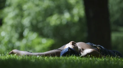 Hombre tumbado en la pradera del Parque del Oeste, España, Madrid