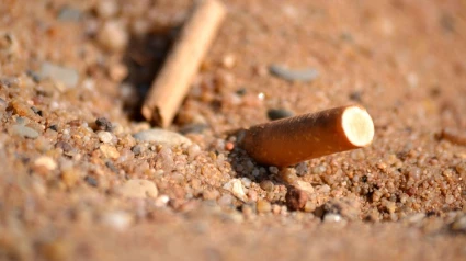 Colilla de un cigarro en la arena de una playa