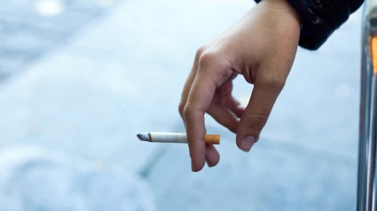 Una persona con un cigarrillo en la mano