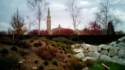 Universidad Laboral de Gijón, al fondo, con un jardín en primer plano