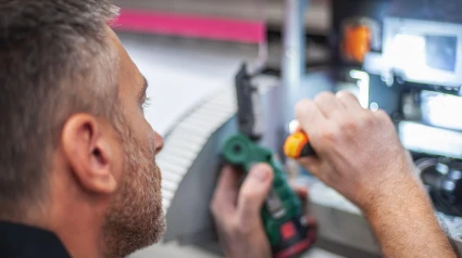 Técnico profesional que soluciona problemas y repara las máquinas de la imprenta.