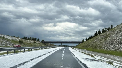 Una tormenta de granizo cubre este martes, la autovía A-50 a la altura de la localidad abulense de Las Berlanas