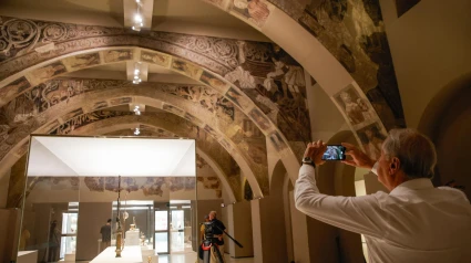 Un hombre fotografía las pinturas murales del Monasterio de Sijena expuestas en el Museu Nacional d’Art de Catalunya (MNAC), a 29 de mayo de 2025, en Barcelona
