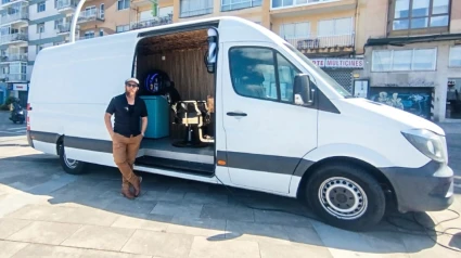 Juan Carlos junto a su barbería móvil