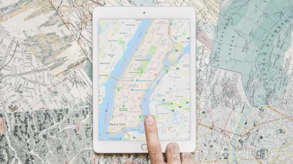 Un hombre consulta la cartografía en una tablet sobre un mapa
