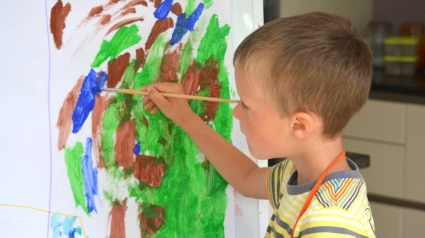 Niño pintando sobre un lienzo