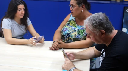 Dos voluntarios hacen una entrevista-encuesta a una usuaria de la fundación, Luana