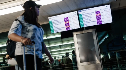 Mujer con maleta en estación de trenes