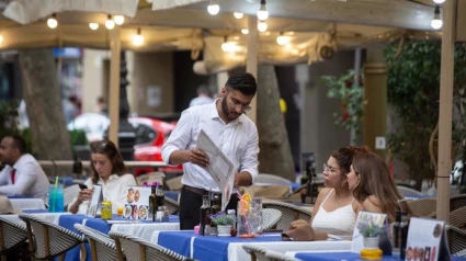 Camarero atiende a clientes en una terraza